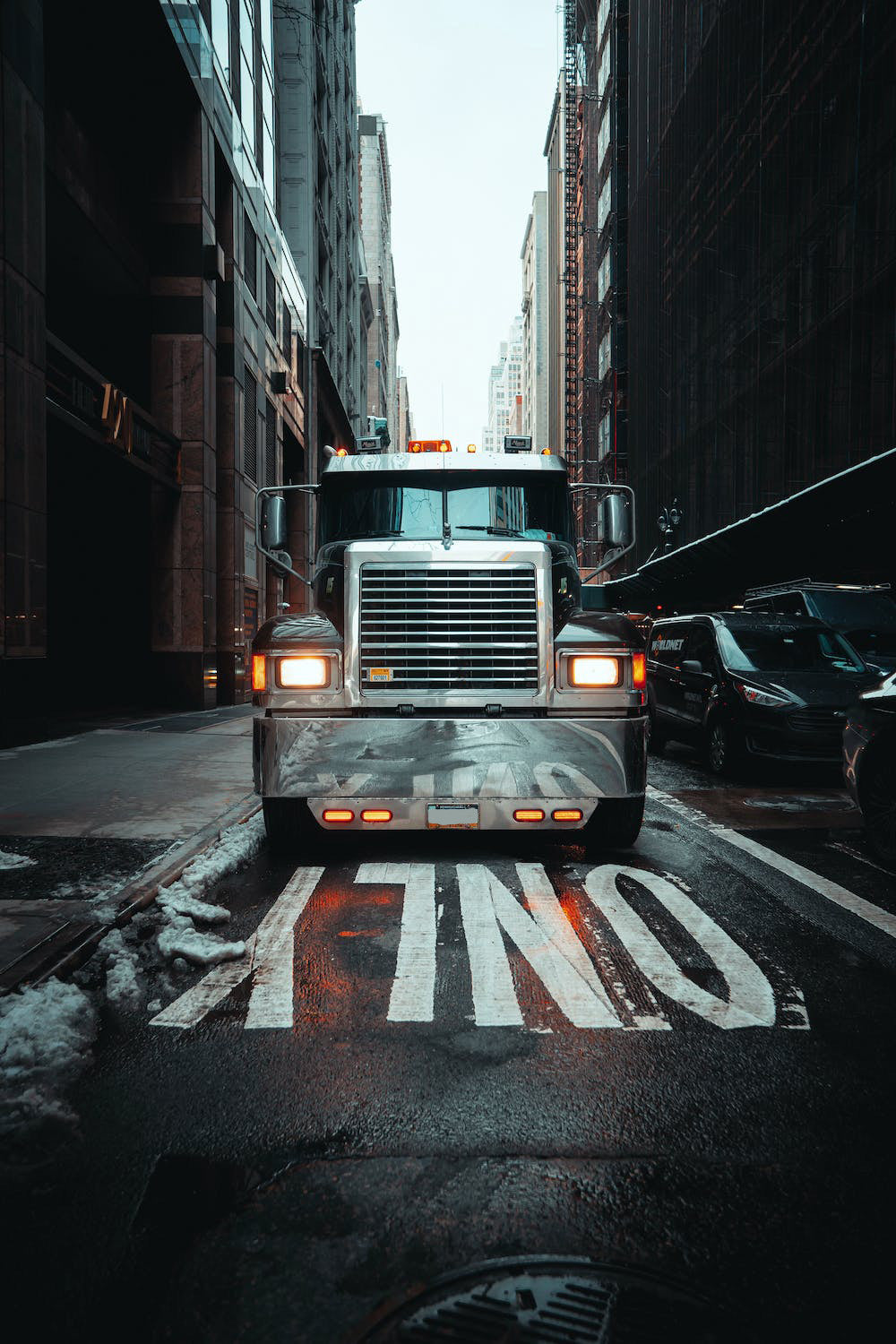 Semi-truck drives through the streets of a city.